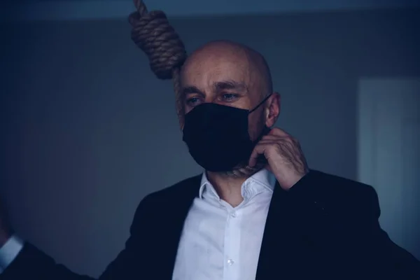 Een suïcidale man met een gezichtsmasker met een strop om zijn nek.. — Stockfoto