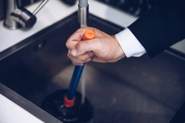 A férfi kezek dugattyút helyeznek a mosogatóra.. — Stock Fotó