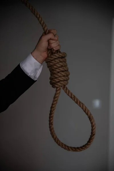 Un uomo d'affari tiene in mano un cappio di corda da appendere. — Foto Stock