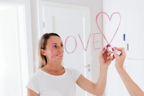 Donna romantica che disegna il cuore su specchio da rossetto. — Foto Stock
