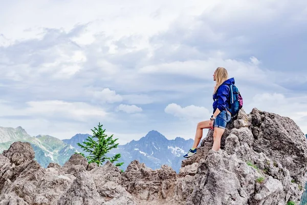 Um turista loiro está sentado em uma rocha nas belas montanhas polonesas. — Fotografia de Stock