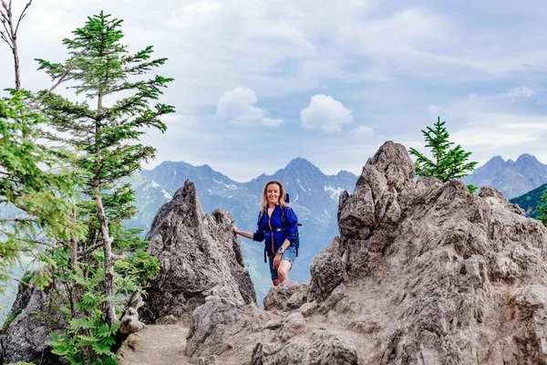 Randonneur souriant est debout sur le sentier de montagne dans les hautes montagnes. — Photo