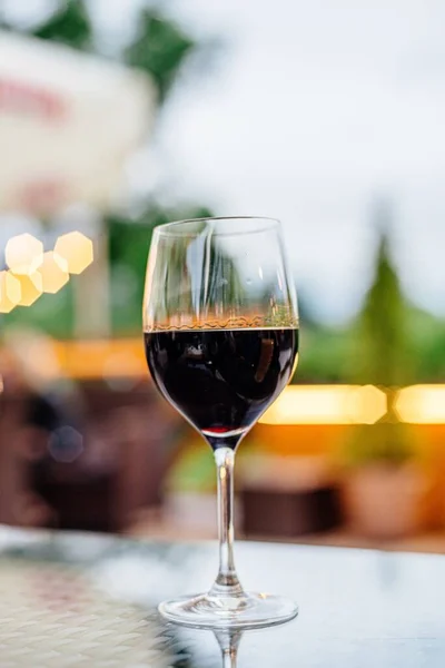 Rött vinglas på ett träbord i restaurang. — Stockfoto