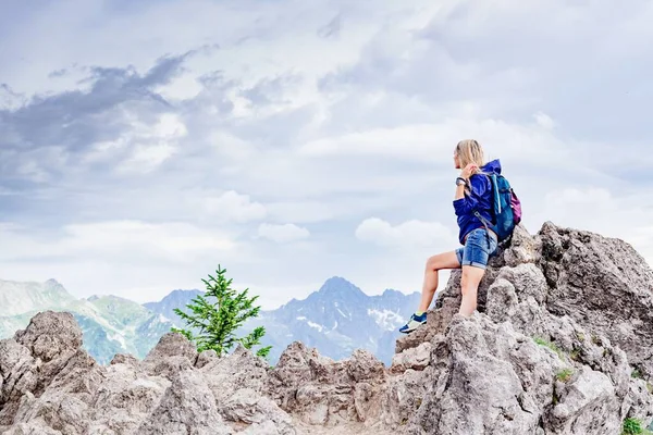 Vue arrière d'une voyageuse debout sur un rocher dans les montagnes. — Photo