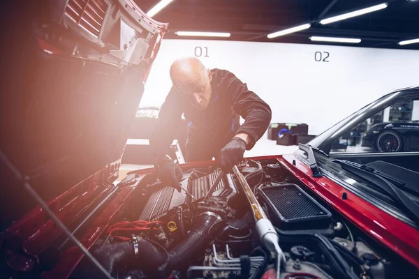 Uomo riparazione motore auto con i suoi strumenti. — Foto Stock