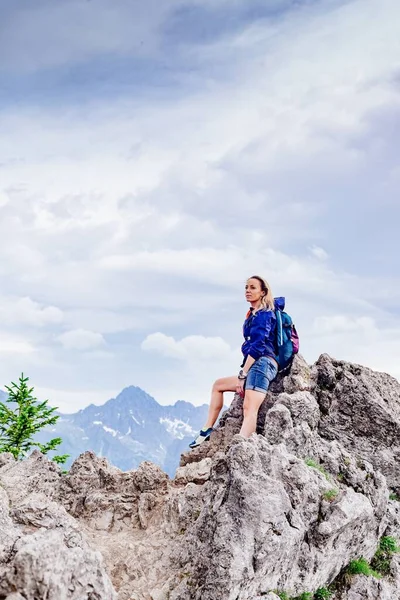 Mulher viajante de pé sobre uma rocha nas montanhas. — Fotografia de Stock