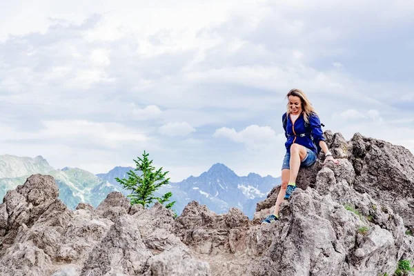 A sortuda viajante feminina desce das rochas nas belas montanhas. — Fotografia de Stock