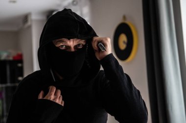 Elinde bıçakla siyah giyinmiş bir haydut..