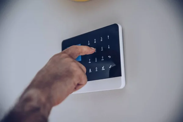 Hombre introduciendo pin de código en el teclado del sistema de alarma para el hogar. —  Fotos de Stock