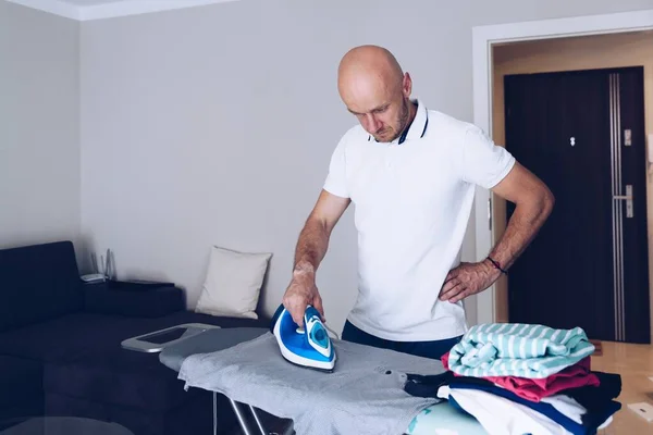 Uomo a casa a stirare vestiti. Concetto di lavori domestici. — Foto Stock