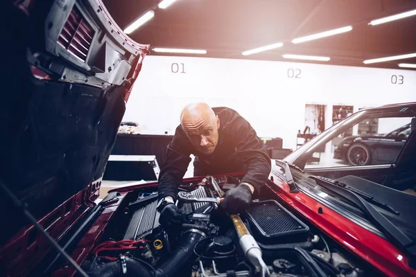 Hombre reparación de motor de coche con sus herramientas. — Foto de Stock