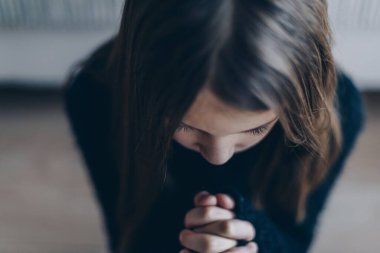 Kız dua ediyor, elleri bağIı inanç ve umut için dua ediyor..