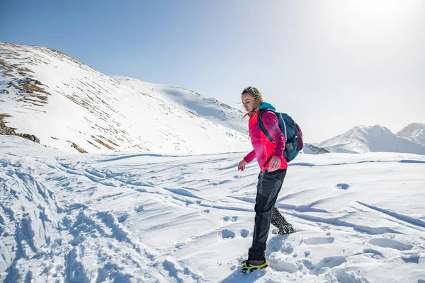 A tourist in a red jacket and backpack in beautiful inspirational winter mountains. — Φωτογραφία Αρχείου