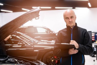 Tamirci ya da araba sahibi arabayı kontrol edip belgeleri dolduruyor