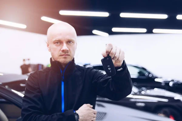 Car mechanic in service holding car keys — Fotografia de Stock