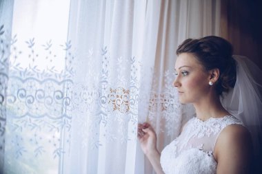 Evdeki düğün töreninden önce pencerenin yanındaki güzel gelin..