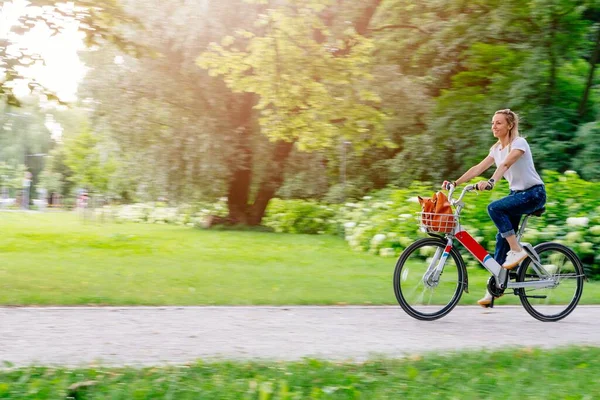 Gyönyörű és vidám felnőtt nő élvezni kerékpározás napfényes városi szabadtéri szabadidős tevékenység a városban. — Stock Fotó