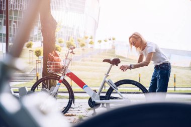 Bir kadın, büyük bir şehrin sakini, mobil bir uygulama aracılığıyla bisiklet kiralıyor..