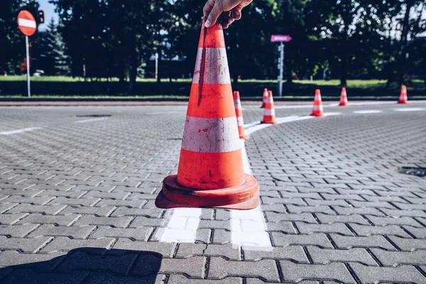 Cones vermelhos dispostos na rua, enquanto listras são pintadas na estrada — Fotografia de Stock