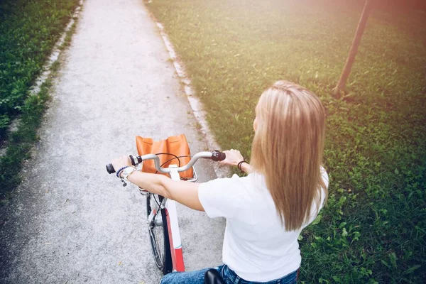 Vue arrière d'une femme en t-shirt blanc avec un vélo de ville. — Photo