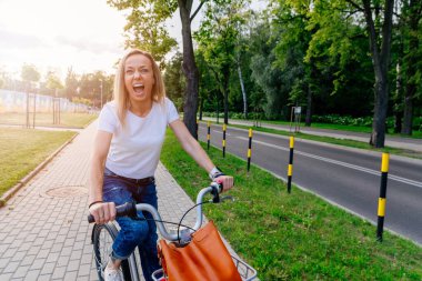 Şehirde bisikletle gezen neşeli bir kadın..