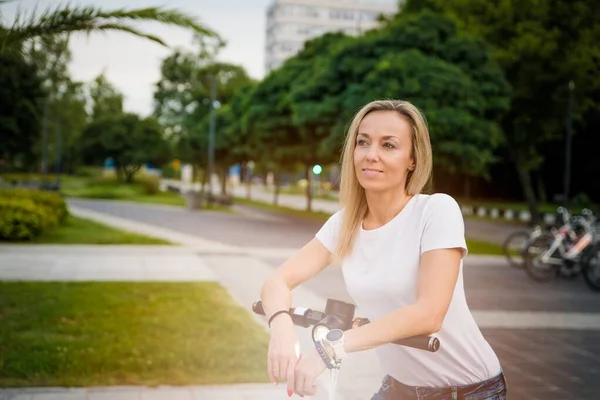 Belle femme chevauchant un scooter électrique pour travailler, nouvelle génération, transport électrique, écologie. — Photo