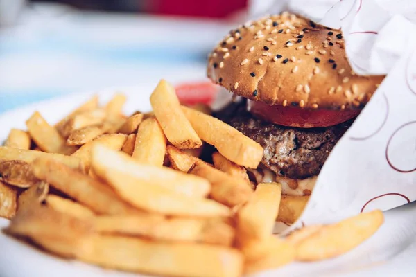 Tasty beef burger with fresh garden vegetables and fries. — Stock Photo, Image