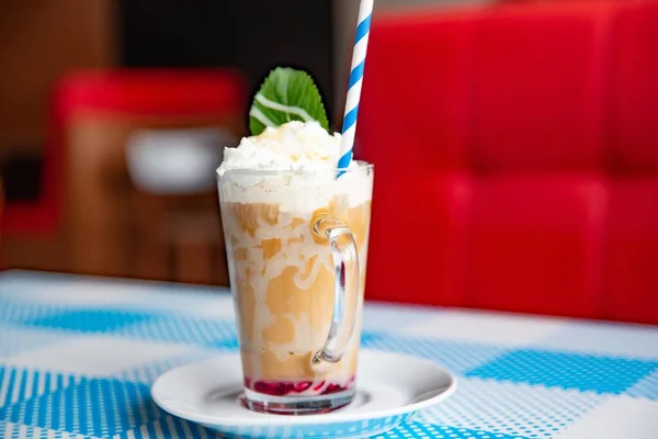 Iced caramel latte coffee in a tall glass with whipped cream. — Stock Photo, Image