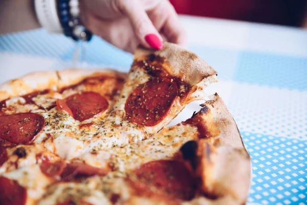 Pizzayı elimle alıyorum. Sıcak İtalyan biberi..