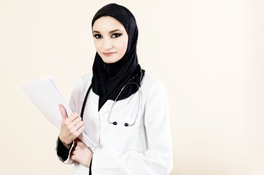 Belgeleri holding beyaz paltolu Müslüman kadın doktor