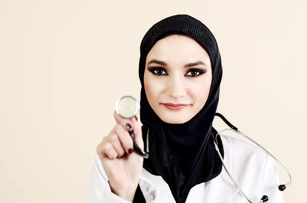 Médica muçulmana de jaleco branco segurando um estetoscópio — Fotografia de Stock