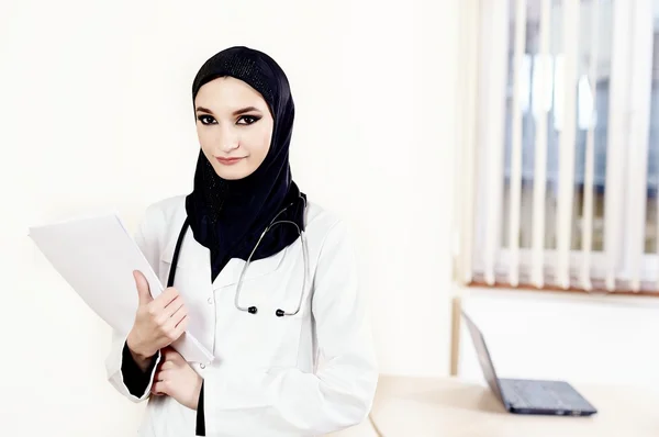 Muslim female doctor standing and holding medical files — Stock Photo, Image