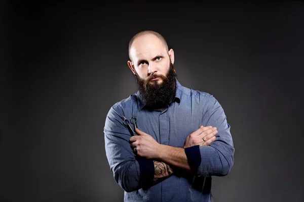 Homem careca com barba a segurar uma tesoura. Mãos cruzadas no peito — Fotografia de Stock