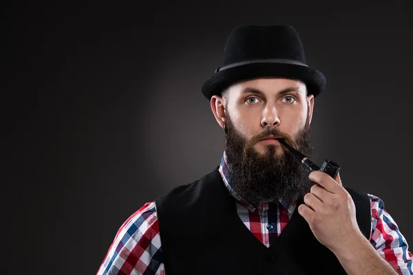 Бородатый мужчина в клетчатой рубашке и шляпе — стоковое фото