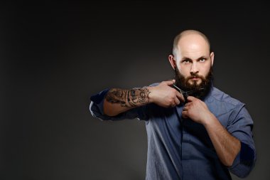 Sakalını makasla kesme sakallı bir adam portresi