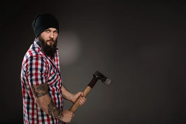 Serious bearded woodcutter holding an axe — Stock Photo, Image