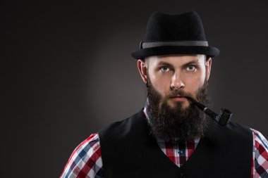 Ağzında pipo tutan kas dövmeli adam