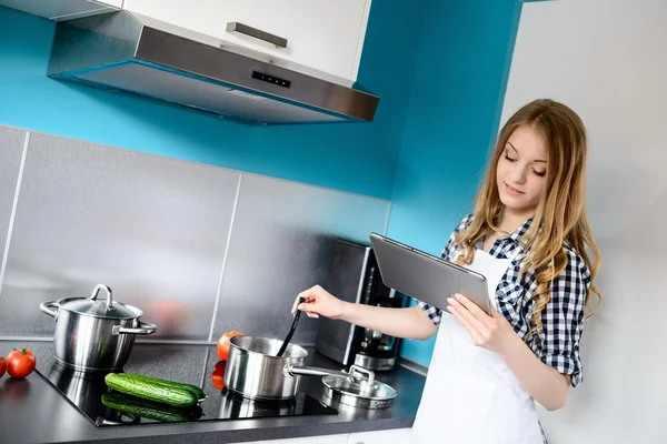 Vacker blond kvinna matlagning middag i köket — Stockfoto