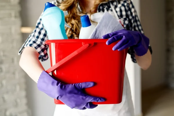 Close-up de mãos de mulher segurando balde cheio de limpadores — Fotografia de Stock