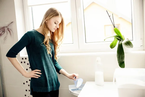 Jonge blonde vrouw gieten waspoeder — Stockfoto