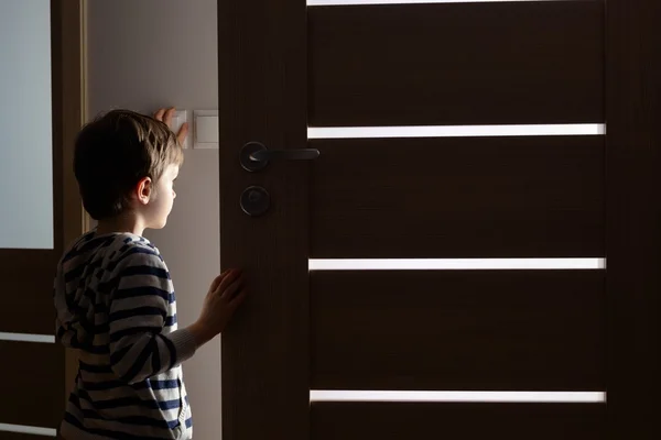 Menino abre a porta para o quarto — Fotografia de Stock