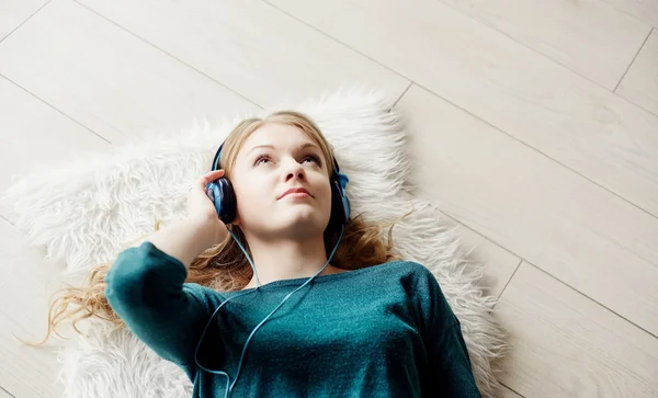 Hermosa mujer rubia escuchando música a través de auriculares —  Fotos de Stock