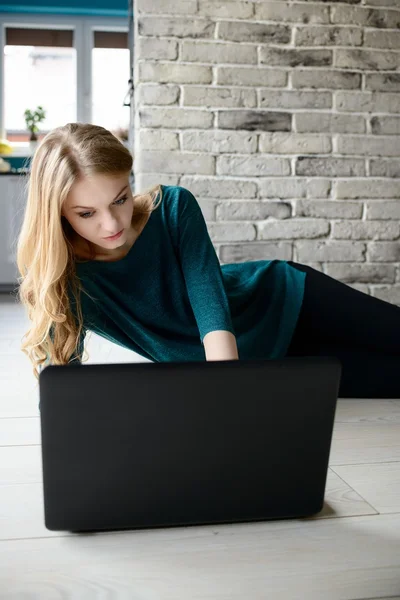 A beautiful blond woman using a laptop — Stock Photo, Image