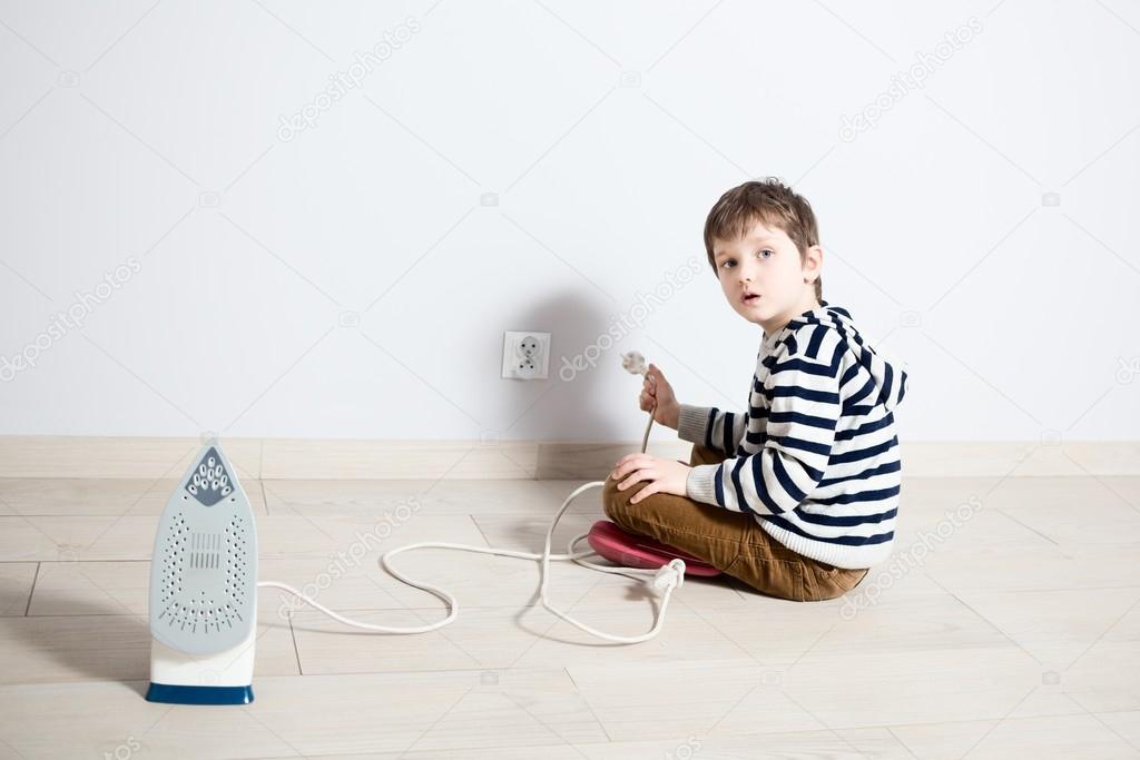 Boy playing dangerously with electric wire