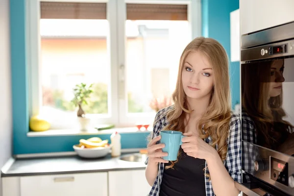 Eine schöne junge blonde Frau trinkt Tee — Stockfoto