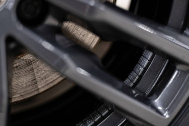 Profesyonel tekerlek servisi sırasında alüminyum alaşımlı kenar içine monte edilmiş yapışkan tekerlek dengeleyici ağırlıkların yakın çekimi, uygun dengeyi sağlamak, titreşim azaltma ve sürüş güvenliği.