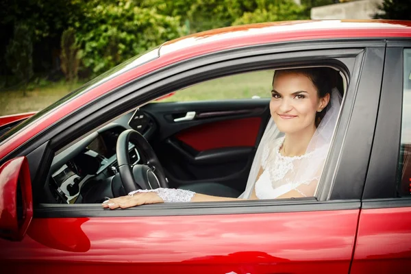 Die Braut sitzt am Steuer eines roten Sportwagens — Stockfoto