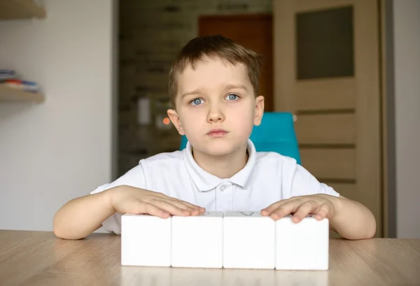 Boy plays with white cubes. Place for your text . — Stock Photo, Image