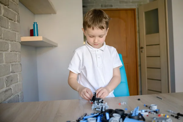 Adorable garçon jouant avec des blocs de plastique techniques à l'intérieur . — Photo