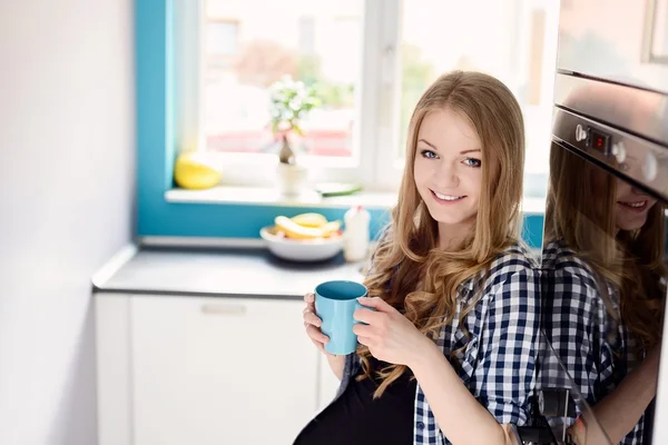 Blonde vrouw drinken thee of koffie — Stockfoto